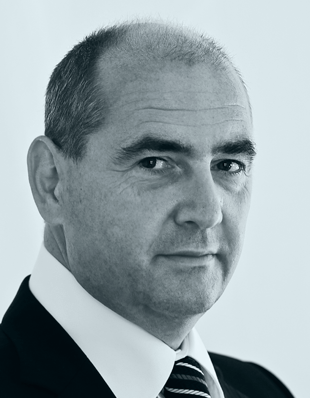 Ein Anwalt in Anzug und Krawatte blickt ernsthaft, repräsentiert DIE KANZLEI MÜLLER & KOLL. im Bereich Zivilrecht.